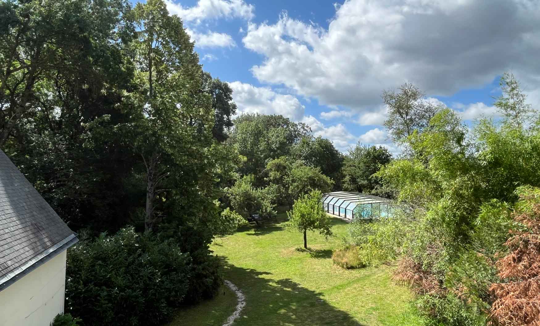 jardin et piscine avec arbres vus du gite